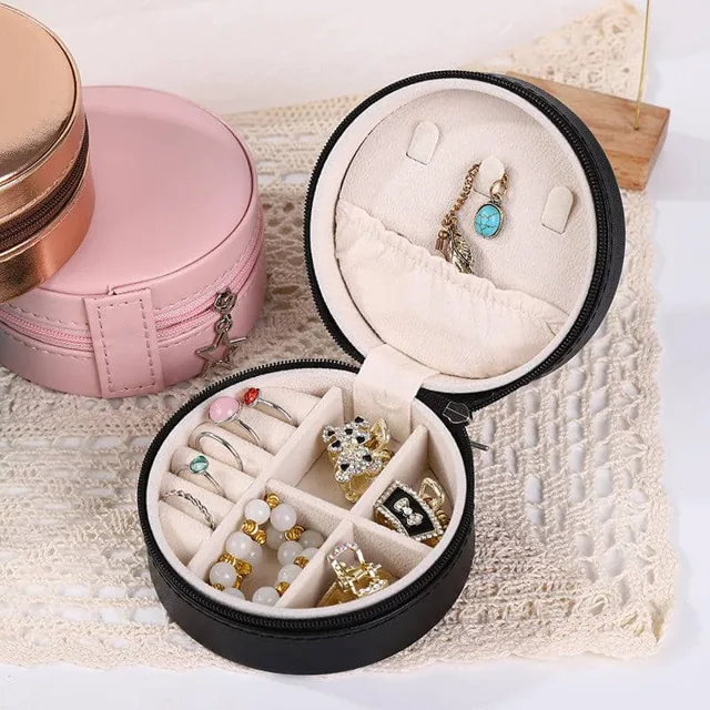 Black round travel case open and filled with jewelry