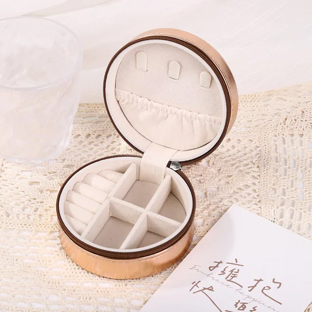 Gold round travel case open showing the mirror and compartments