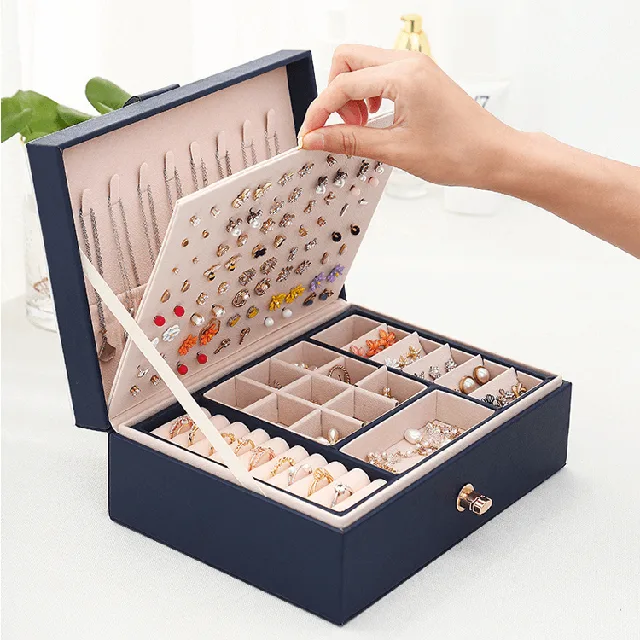 Hand lifting the earring panel out of the navy jewelry case