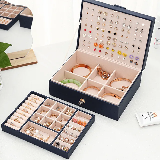 Navy jewelry case open beside a removable divided tray