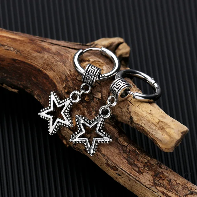 Three star earrings laid on driftwood
