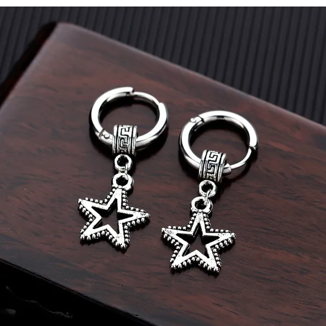 Silver star earrings on a wood surface, close view