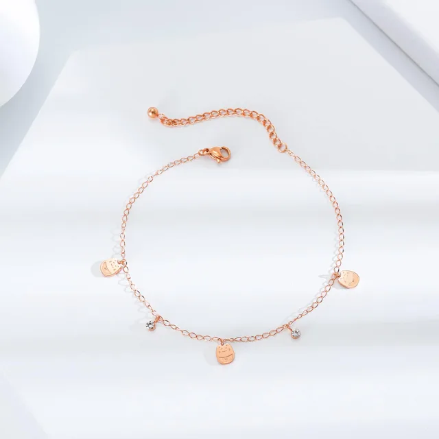 Rose gold disc anklet laid flat on white