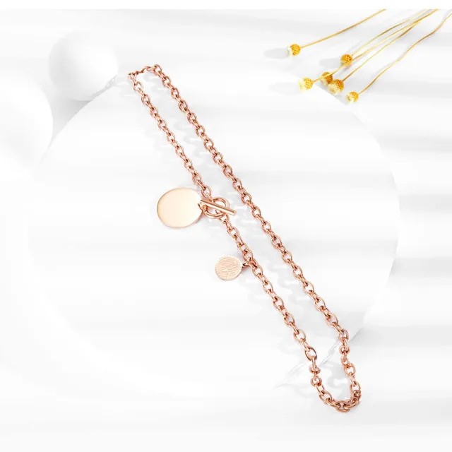 Rose gold disc necklace laid flat with dried flowers
