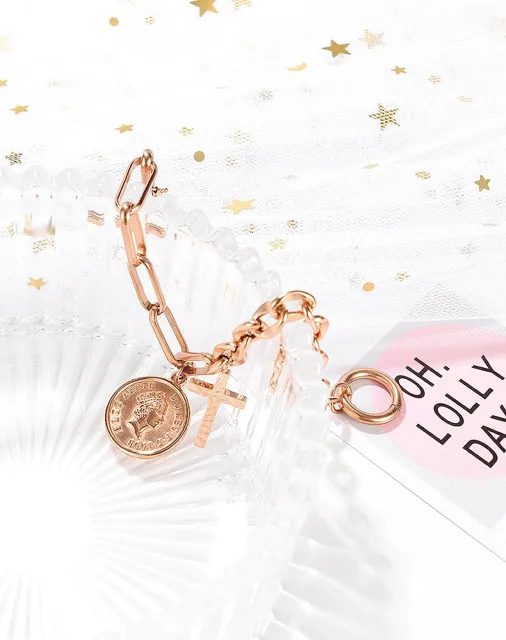 Rose gold coin and cross bracelet on a pink card