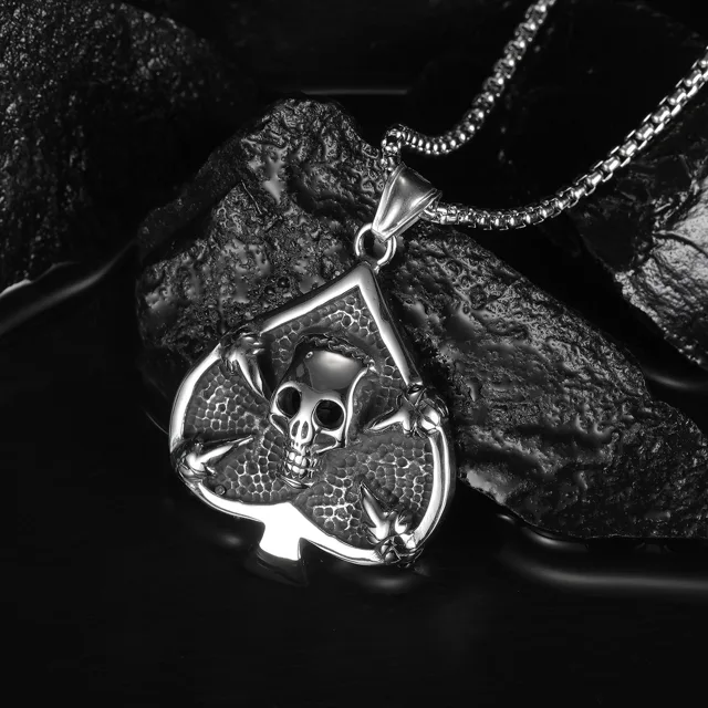 Spade skull pendant photographed on dark rocks