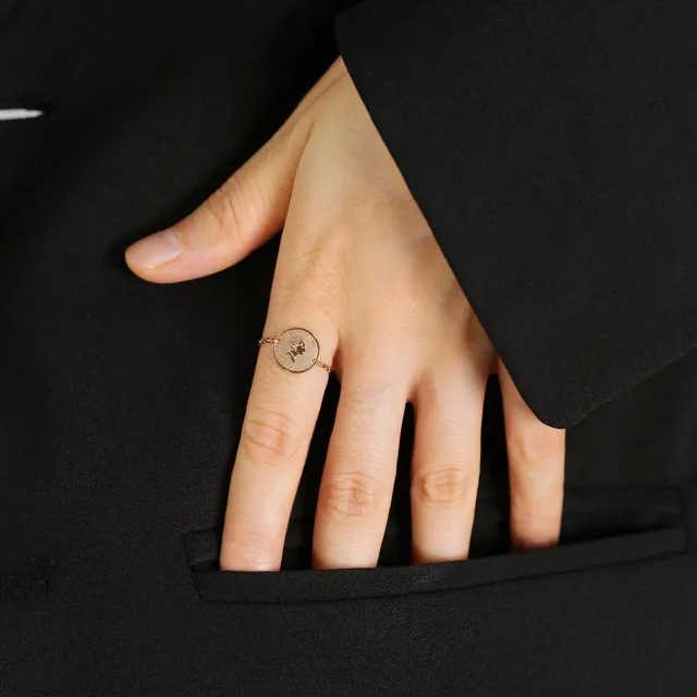 Hand in a black sleeve wearing the chain ring