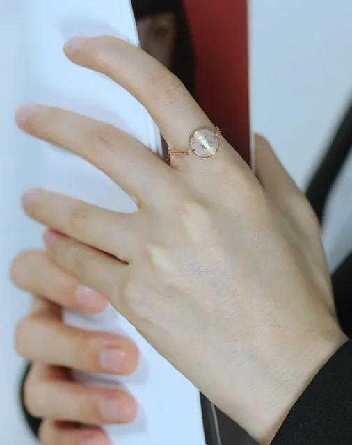 Hand holding a cup wearing the rose gold ring