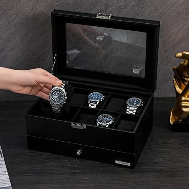 Hand lifting a watch beside the open black storage box