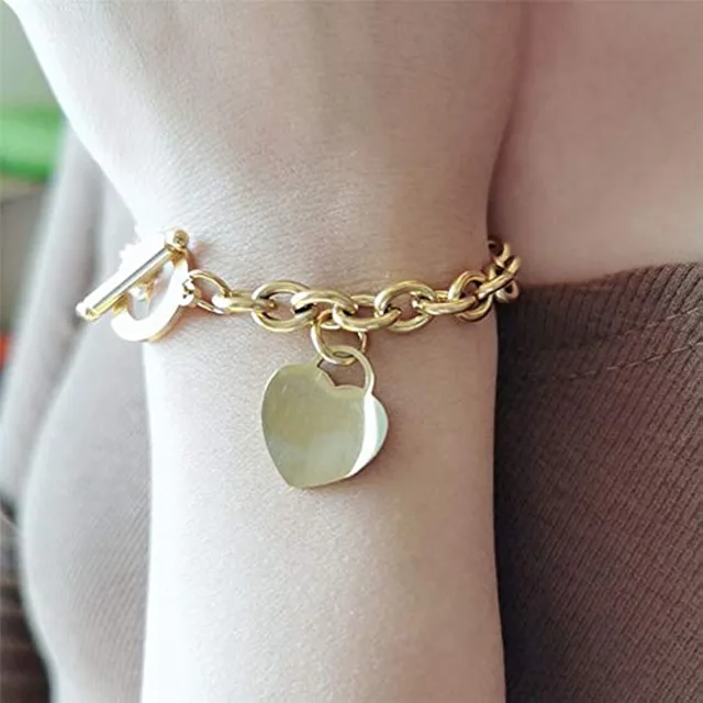 Close view of a silver heart charm worn on the wrist