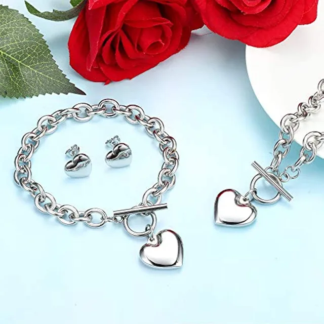 Silver heart set arranged beside roses