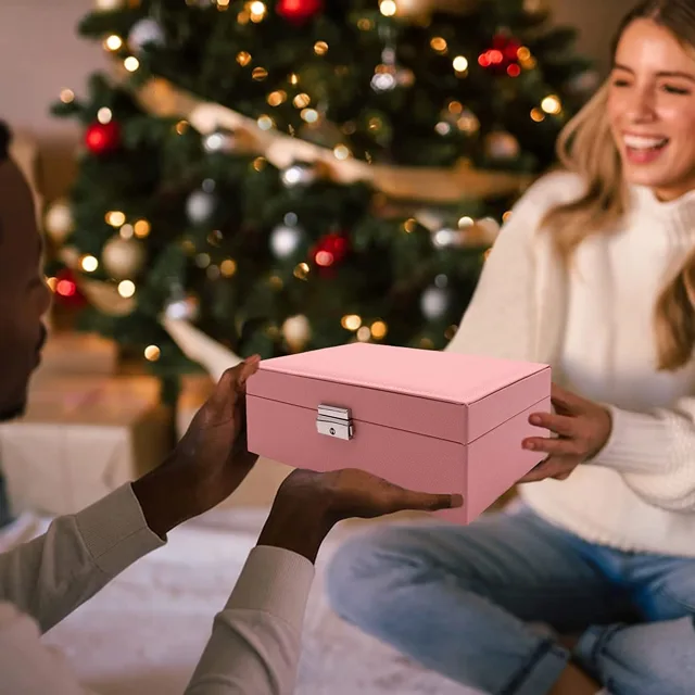 Woman holding the pink jewelry case by a Christmas tree