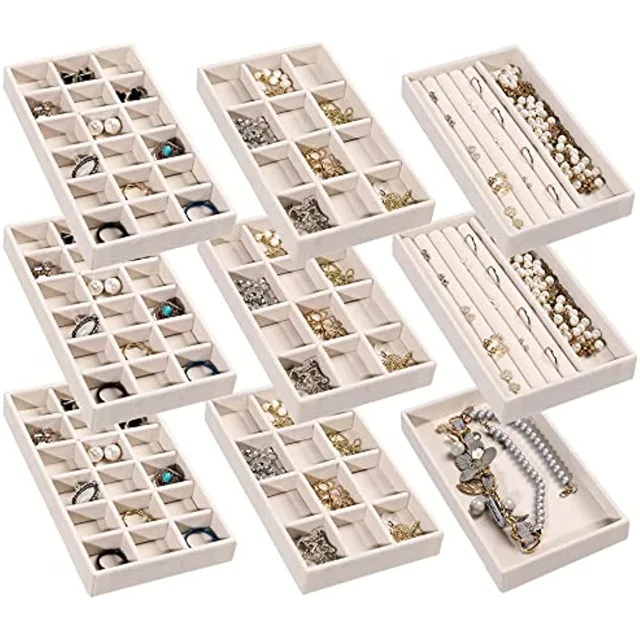 Twelve white velvet trays arranged in a flat-lay grid
