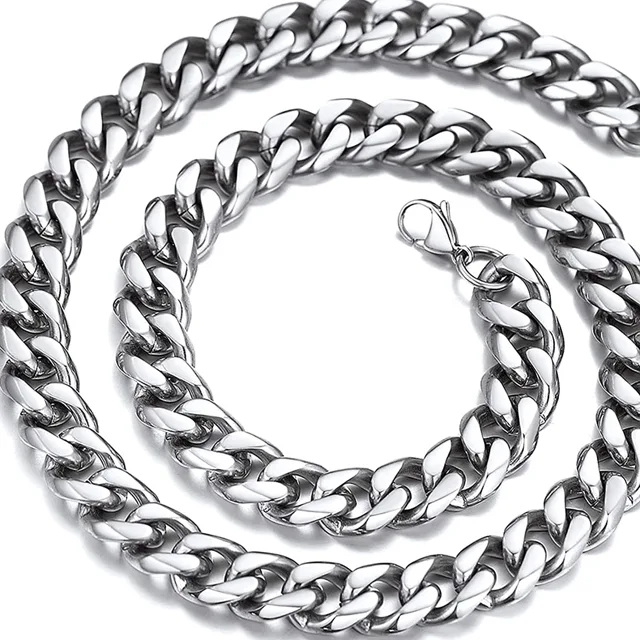 Silver Cuban link chain coiled in a spiral on a dark surface