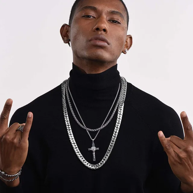 Man in a black turtleneck wearing a silver cross pendant chain