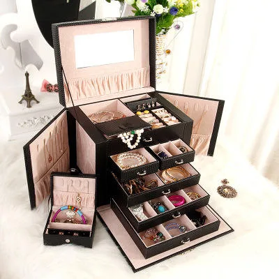 Black jewelry cabinet styled on a dressing table with roses