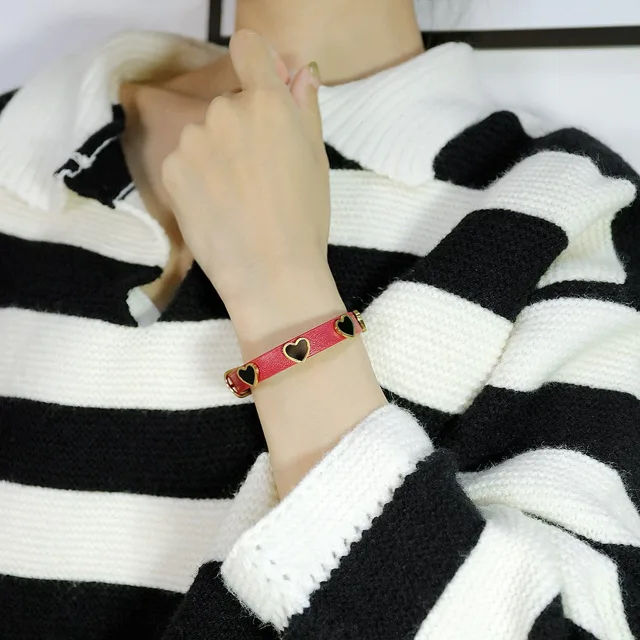 Wrist wearing the red heart-stud bracelet