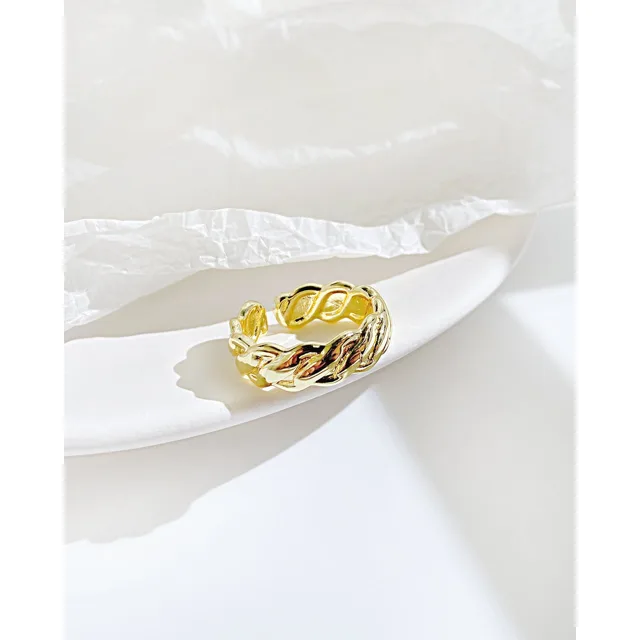 Twisted gold ring on a white dish