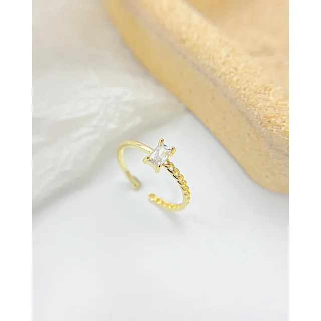 Gold twisted open ring on white linen