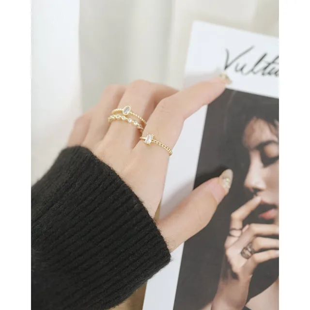 Hand in a black sleeve wearing stacked star rings