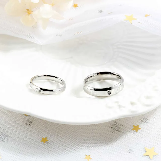 Silver wedding bands on a white dish with stars