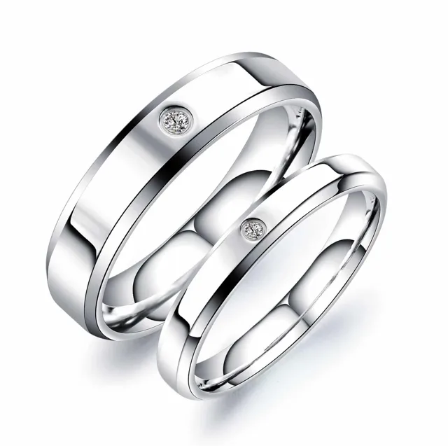 Silver wedding band pair standing crossed