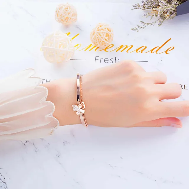 Wrist in white knitwear wearing the butterfly bracelet