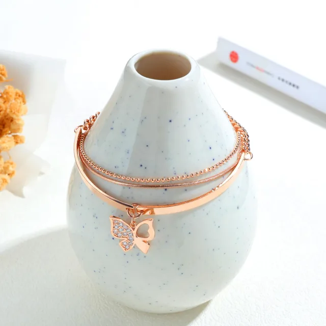 Rose gold bracelet wrapped around a white vase