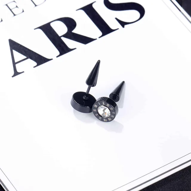 Black stud earrings beside a Paris card