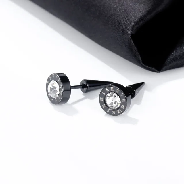 Black stud earrings, close view on fabric