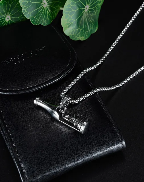 Bottle pendant resting on a black wallet with leaves
