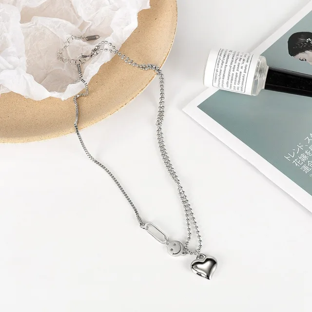 Double-chain heart necklace on a wooden desk