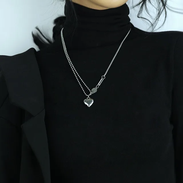 Model in a black turtleneck wearing the heart necklace