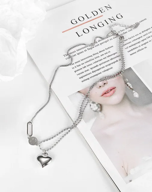 Silver heart necklace styled on a magazine