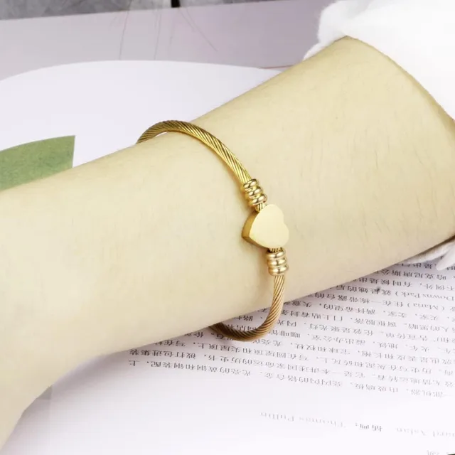 Gold open cuff bracelet worn on a wrist