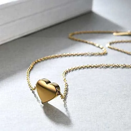Gold heart bracelet and necklace set on a pale background