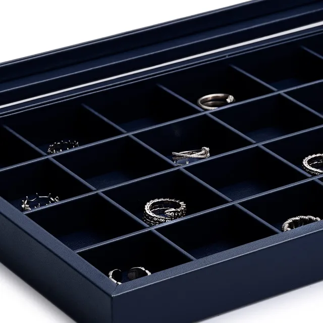 Close view of ring slots holding silver rings in a navy case