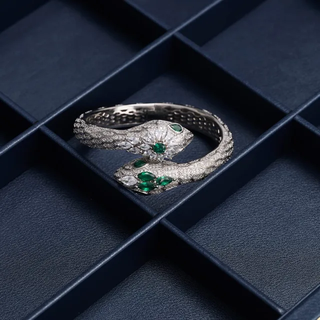 Green pendant necklace placed in a compartment of a navy case