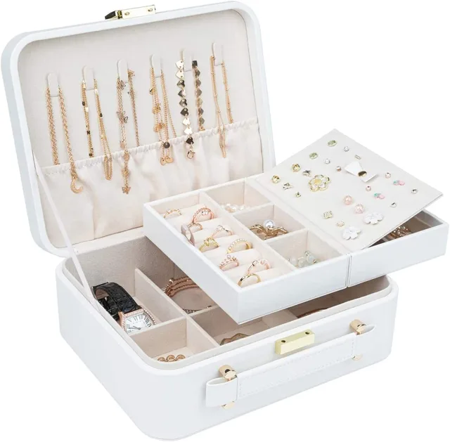 White quilted trunk open with a mirror and filled trays