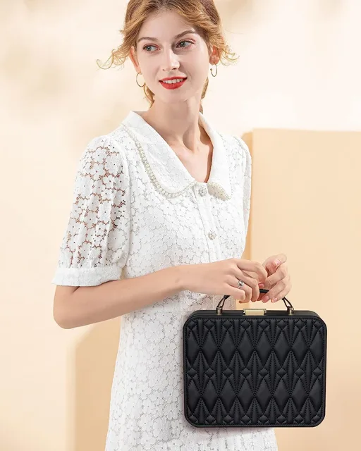 Model in white holding the black quilted jewelry trunk
