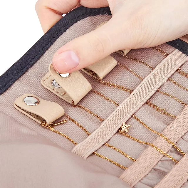 Hands fastening the snap clip on a jewelry organizer flap