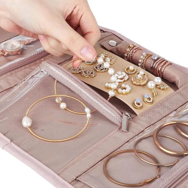 Hand placing a gold bangle into the pink organizer