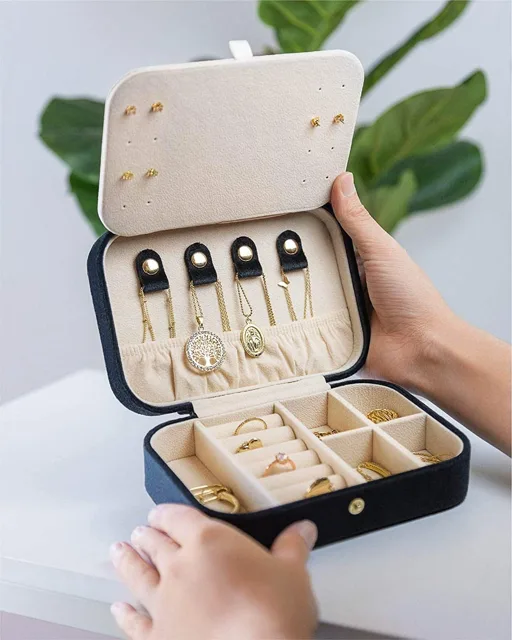 Hands opening the black travel case beside a plant