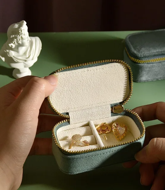 Hands opening the mint case beside a sculpted ornament