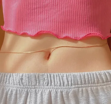 Belly chain worn with a pink top and grey joggers