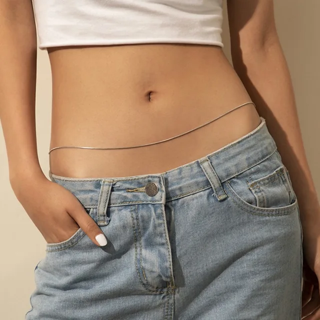Thin gold waist chain worn low on the hips with jeans