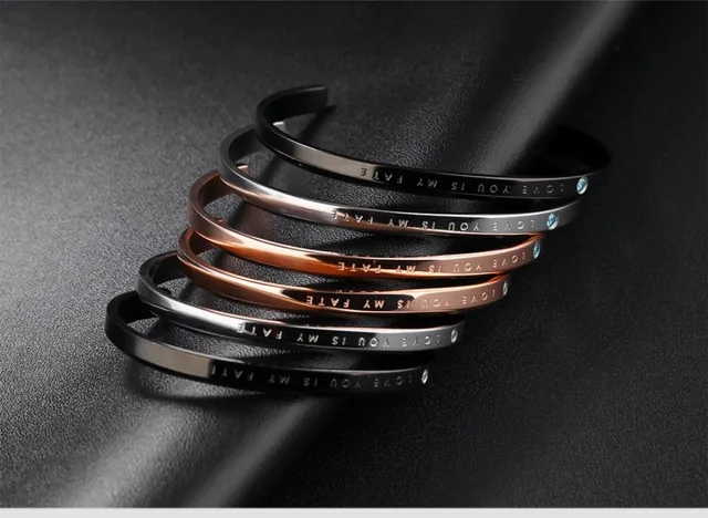 Silver, rose gold and black cuffs stacked on black