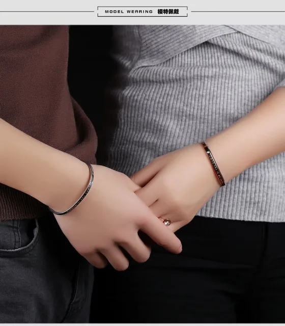 Couple holding hands wearing the black cuffs