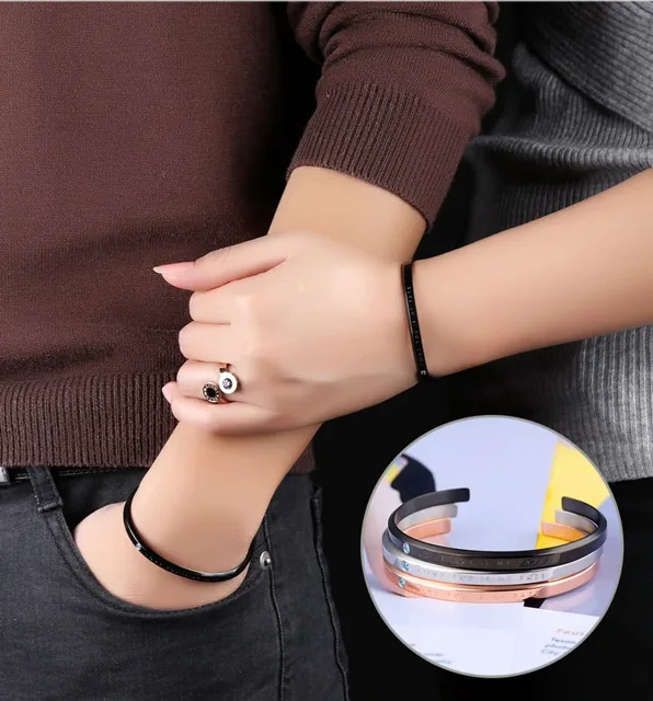 Close view of wrists wearing the black cuff and a ring
