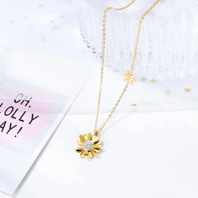 Daisy pendant beside a pink card, close view